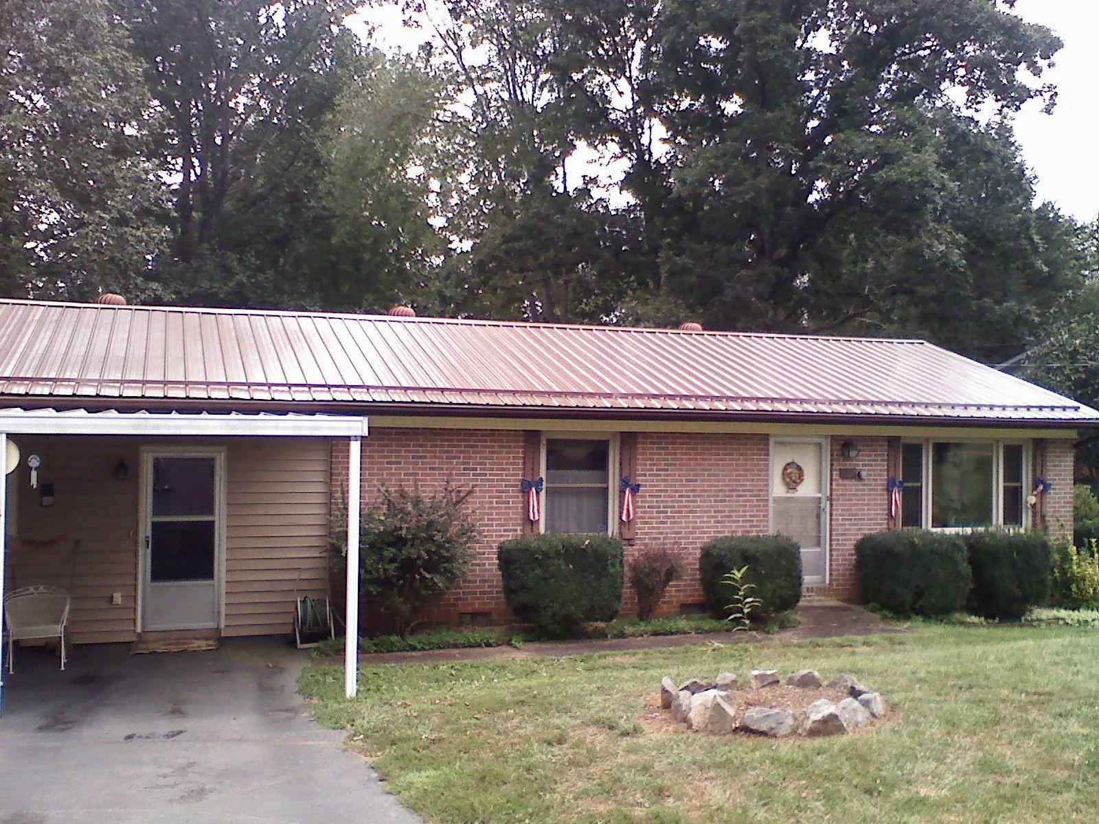 Bronze metal roof and carport on a brick ranch home — Roof Repair work by our crew in Salida